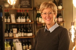 © IHK Trier/Thewalt / Privat/Non-kommerziell Barbara Krebs steht vor einem Weinregal und lächelt freundlich in die Kamera